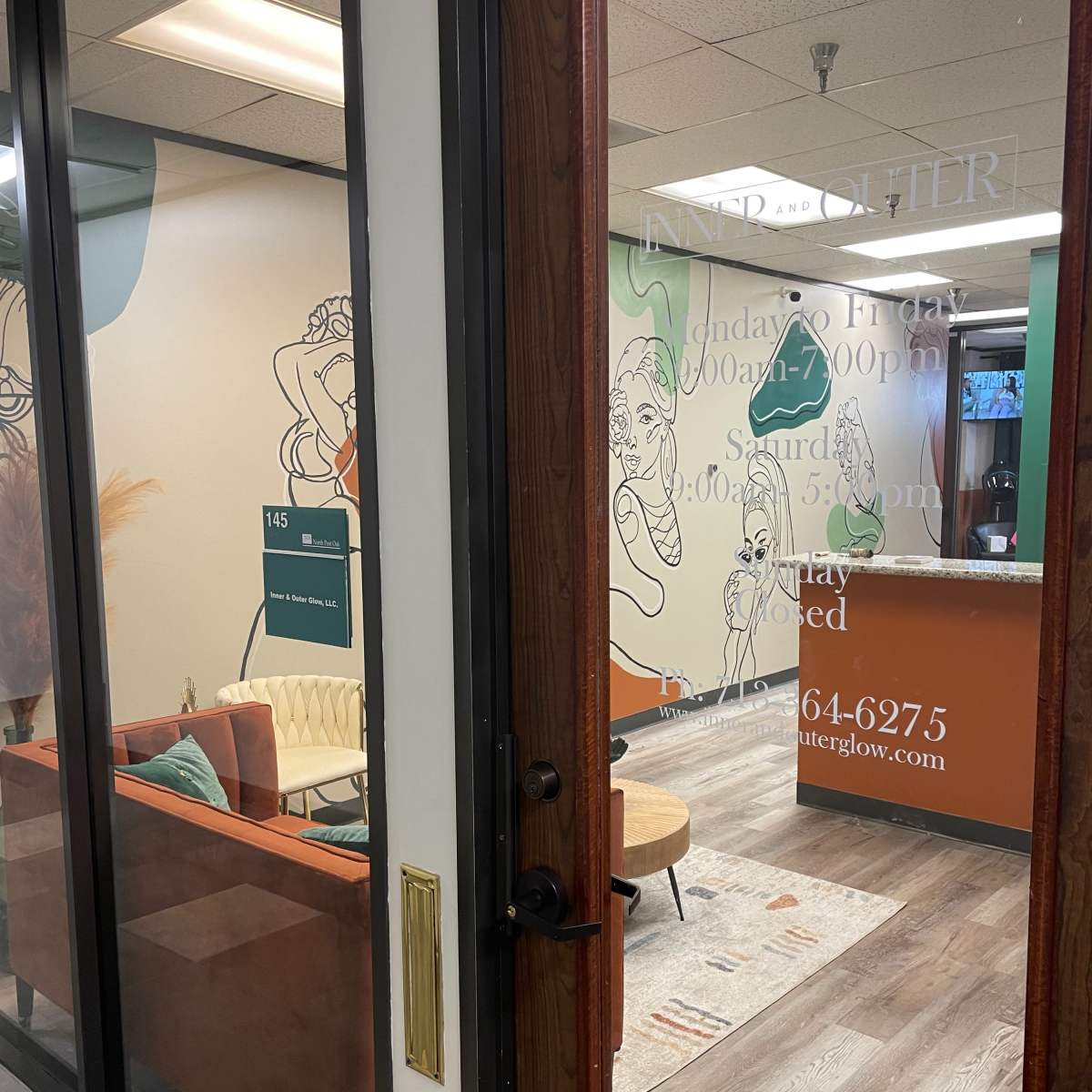 The entrance to a business office with a cozy seating area visible and a reception desk in the background.