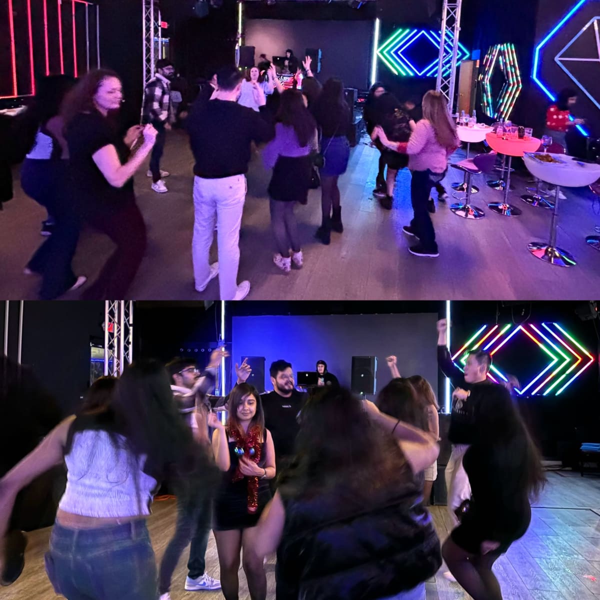 A crowd of people is dancing in a dimly lit venue with colorful neon lights and a stage in the background.