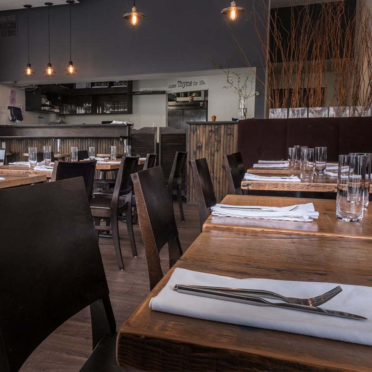 The interior of a restaurant with wooden tables, chairs, and minimalist decor.