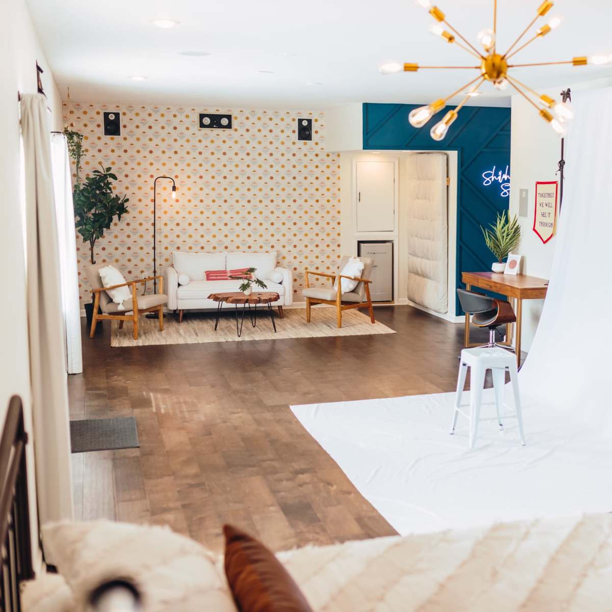 A spacious, well-lit room with a seating area and a white backdrop for photography.