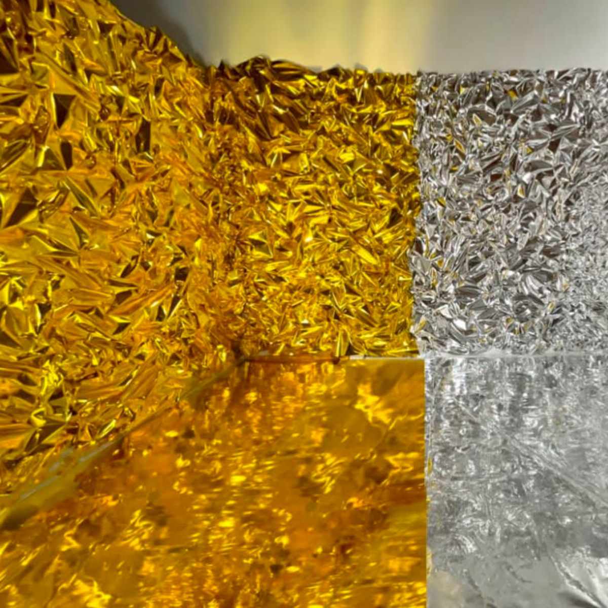 A room where the walls and floor are covered with crumpled gold and silver foil.