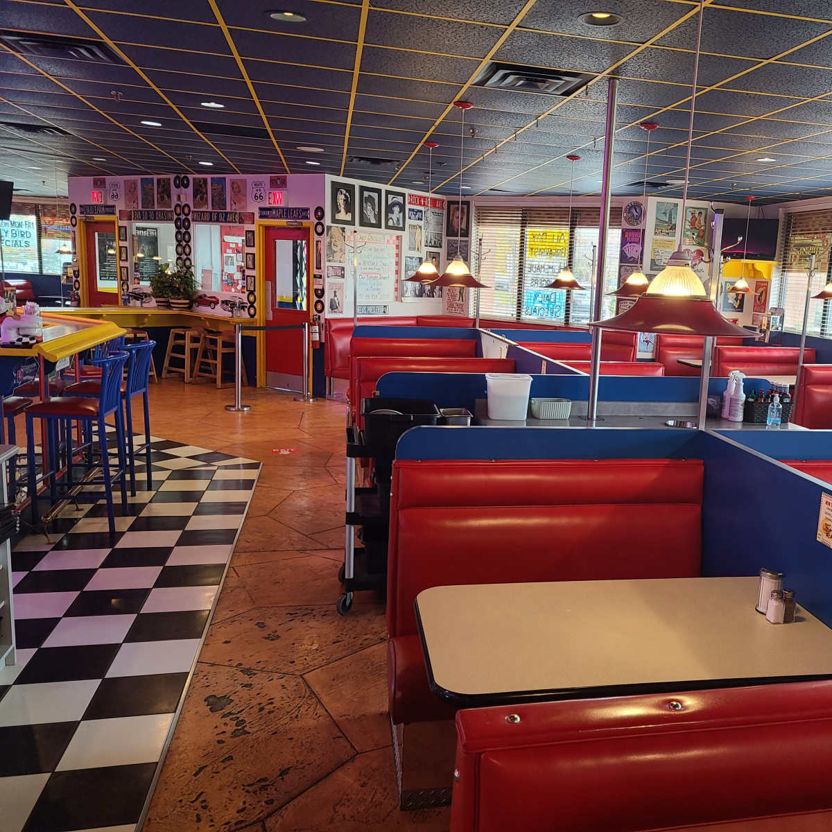An empty diner with red vinyl booths and a checkered floor.