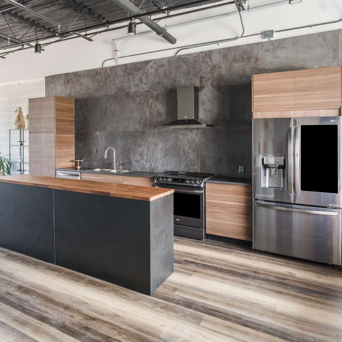 A modern kitchen with a central island, stainless steel appliances, and large windows overlooking a living area.