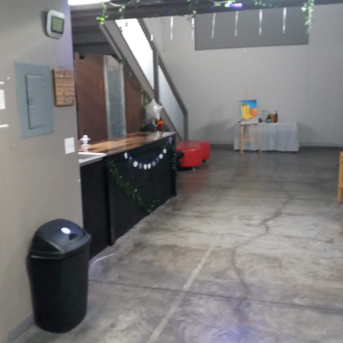 A spacious indoor area with a bar, seating, and restrooms to the left.