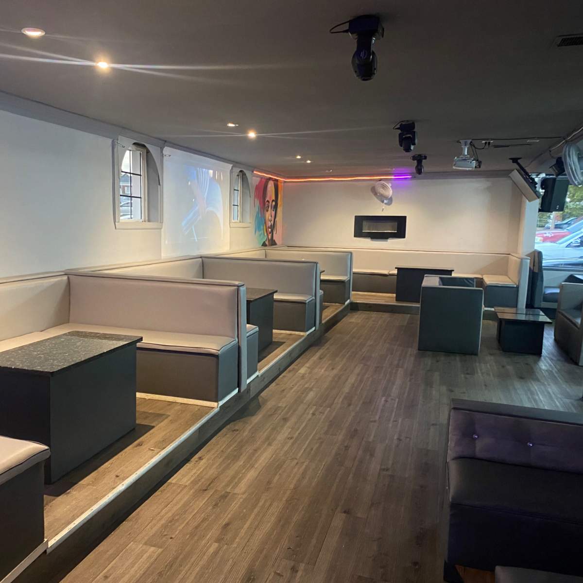A spacious seating area in a modern lounge or bar with booths and tables arranged along the walls.