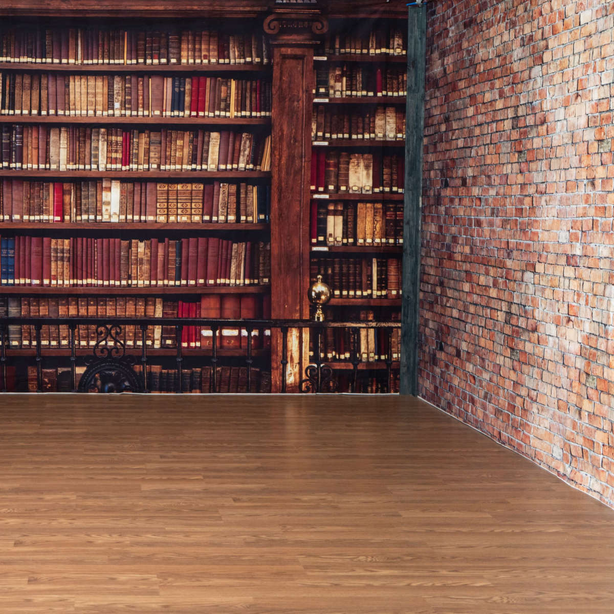 A room with wooden flooring and a large, mural-style wallpaper of a library filled with shelves of books.