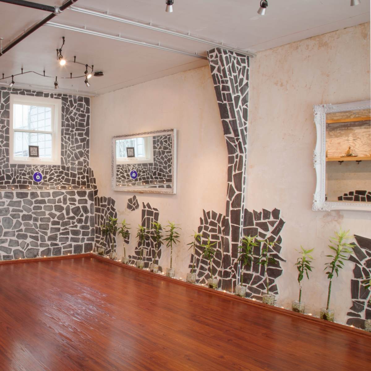The interior space features a unique stone-patterned wall design, wooden flooring, and decorative mirrors.