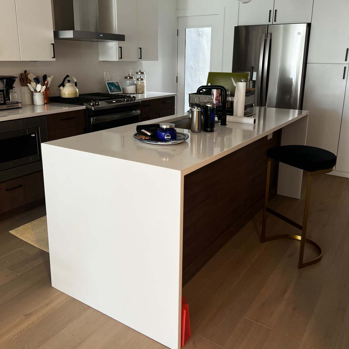 A modern kitchen with a central island, stainless steel appliances, and pendant lighting.