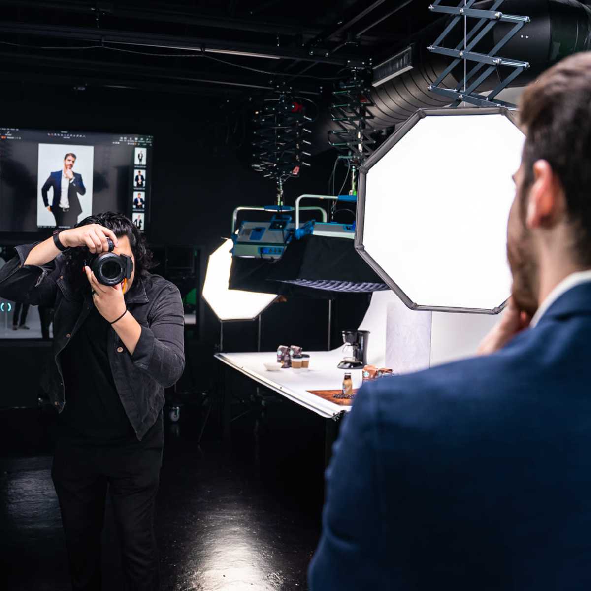 A photographer captures a subject in a studio setting with professional lighting and equipment.