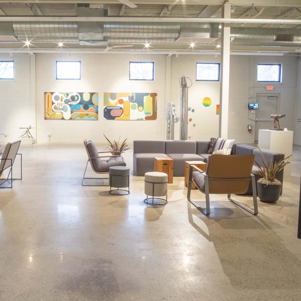 A spacious, modern lounge area with several seating arrangements, art on the walls, and various decorative elements.