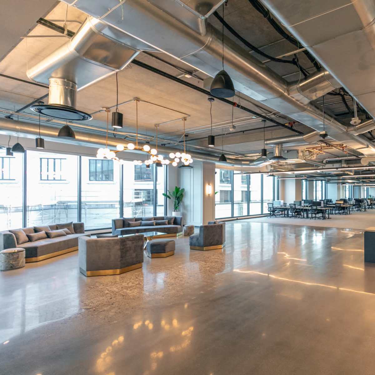 A modern office space with open areas, minimalist furniture, and large windows.