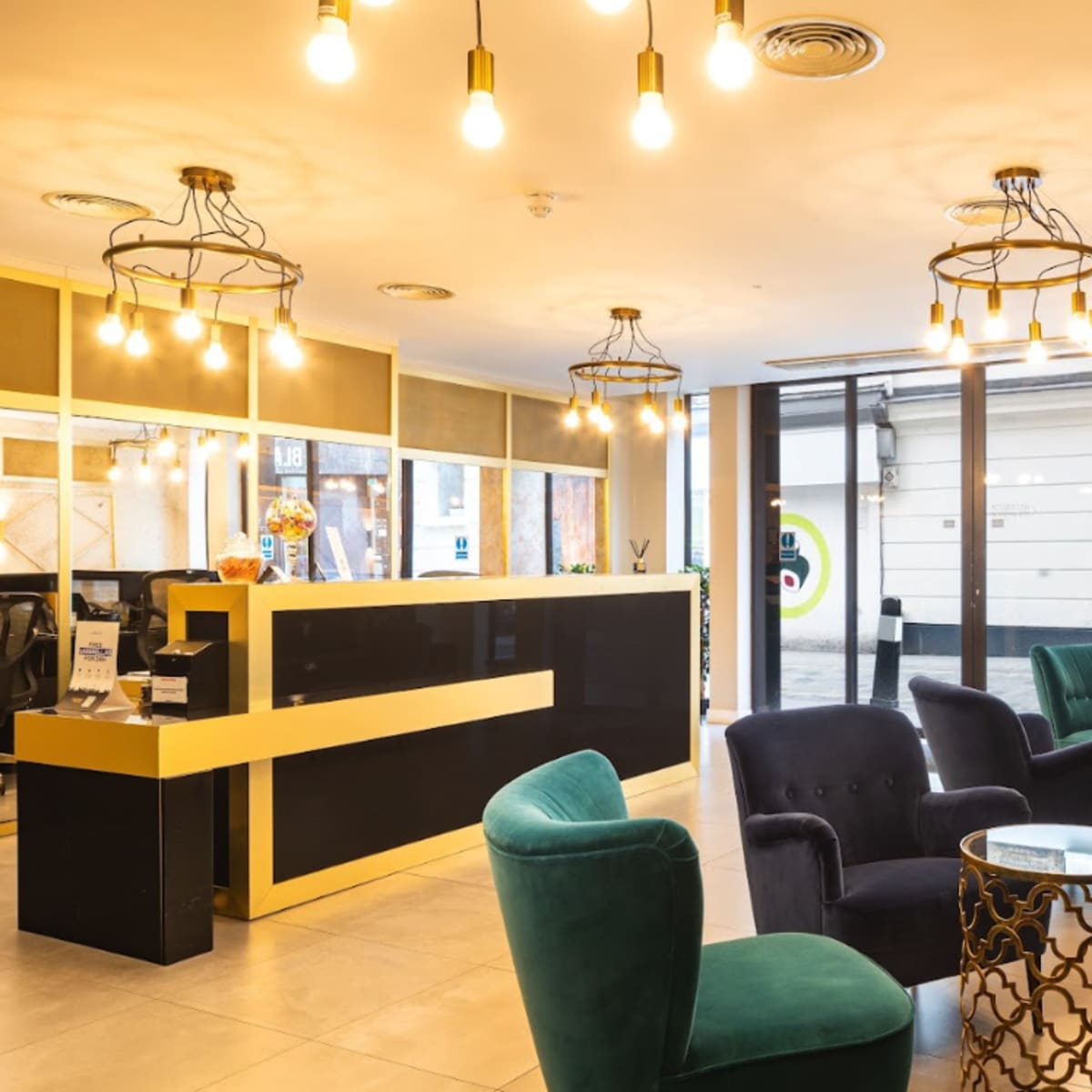 The lobby features a reception desk, dark upholstered seating, and decorative light fixtures.