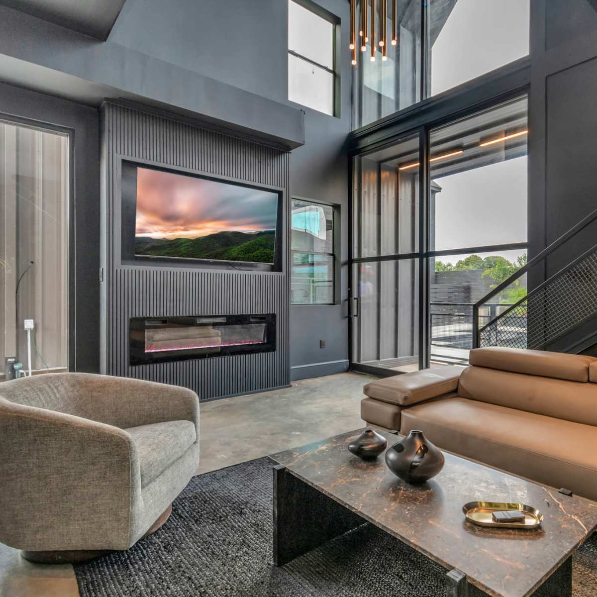 A modern living room with a sleek sectional sofa, a marble coffee table, and large windows showcasing an outdoor view.