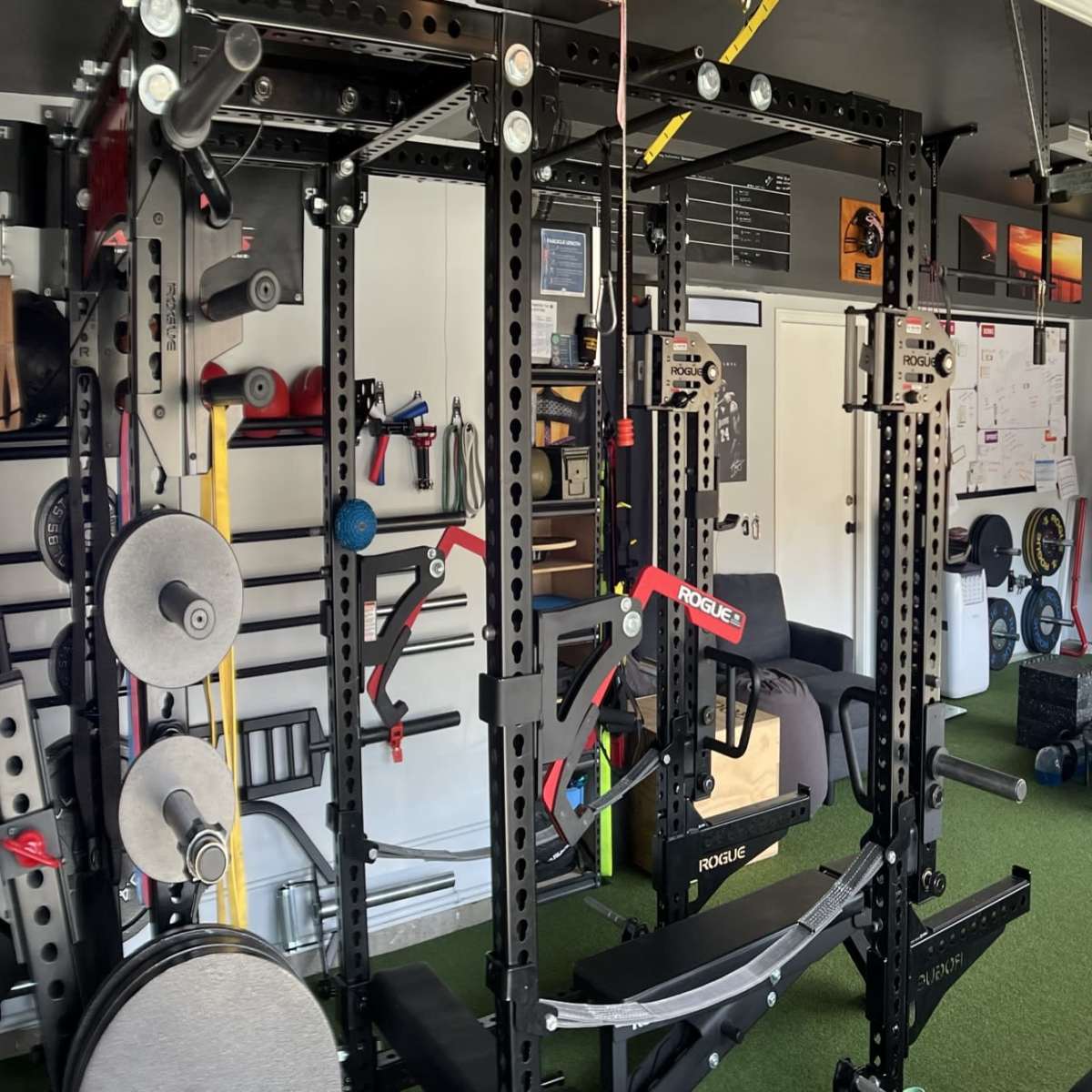 A well-equipped home gym with various exercise machines, weights, and fitness accessories arranged neatly in a garage.