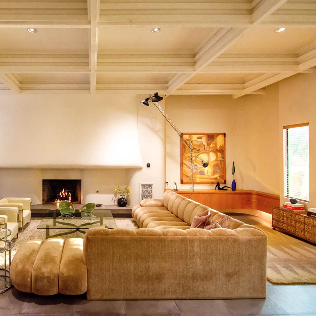 A spacious living room with a large sectional sofa, a fireplace, and a dining area in the background.