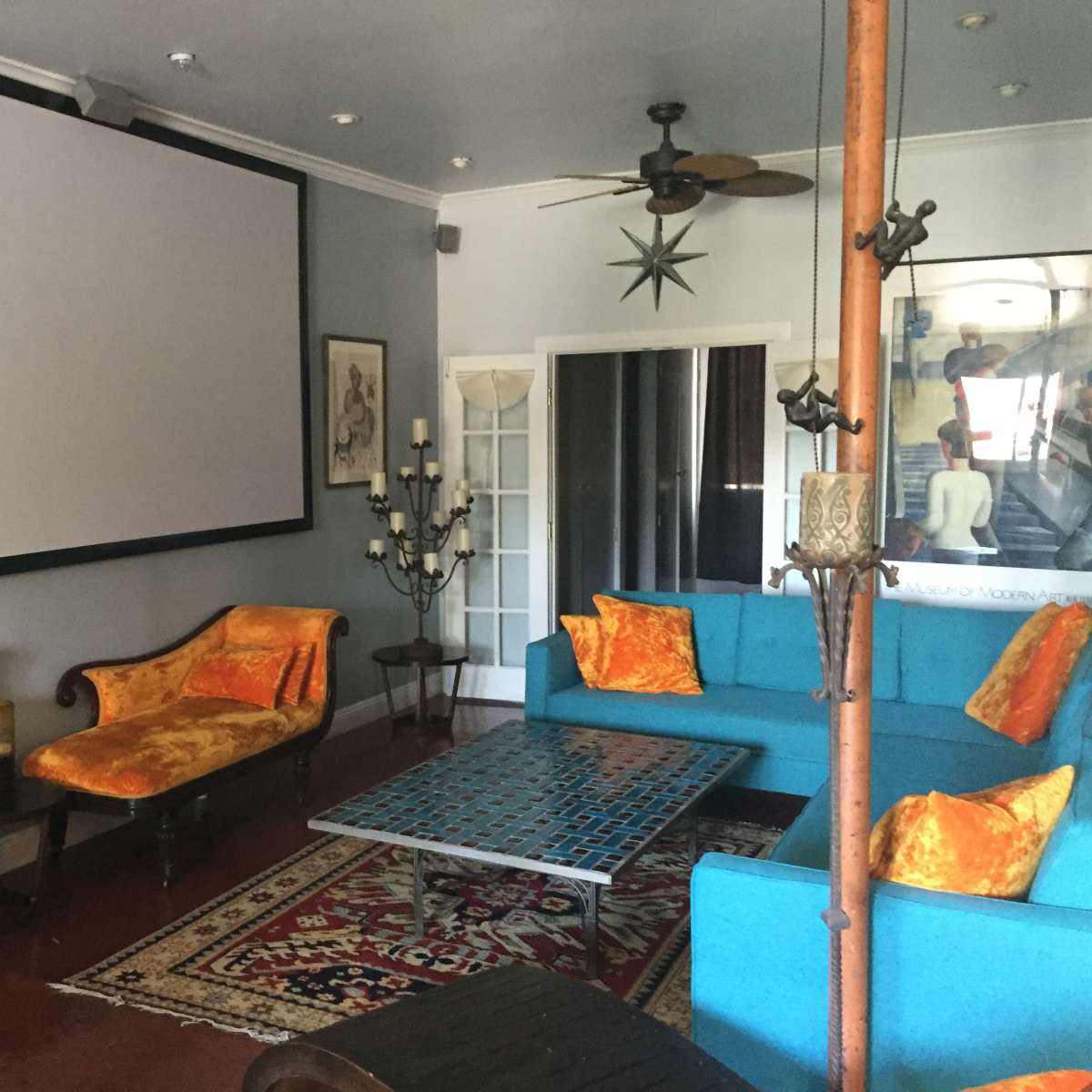 The room features a large projection screen, colorful seating arrangements, and decorative accents on a polished floor.