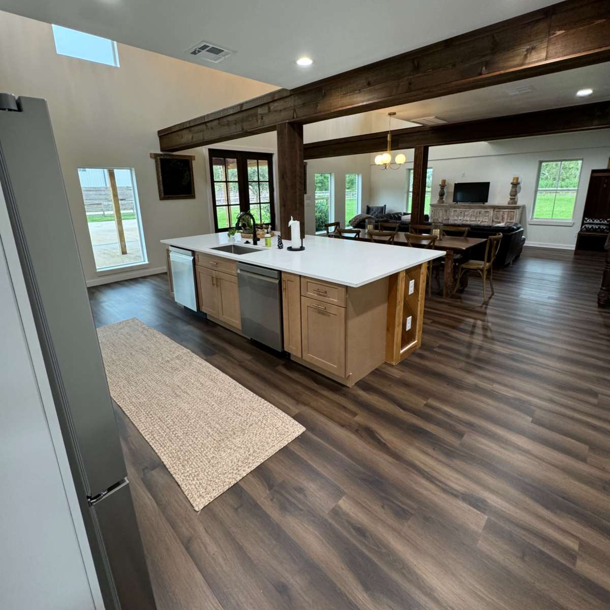 A spacious kitchen with a large island, hardwood floors, and windows that provide natural light.