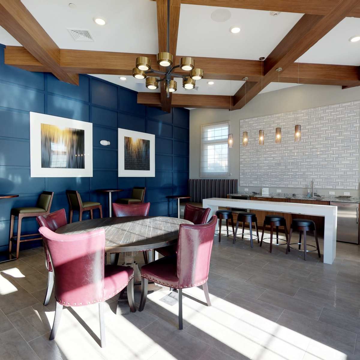 A modern dining area featuring a table with chairs, a bar counter, and decorative wall panels in blue and white.