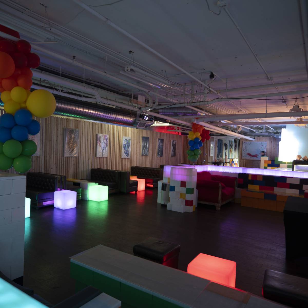 A brightly lit event space with colorful seating and decorative balloons.