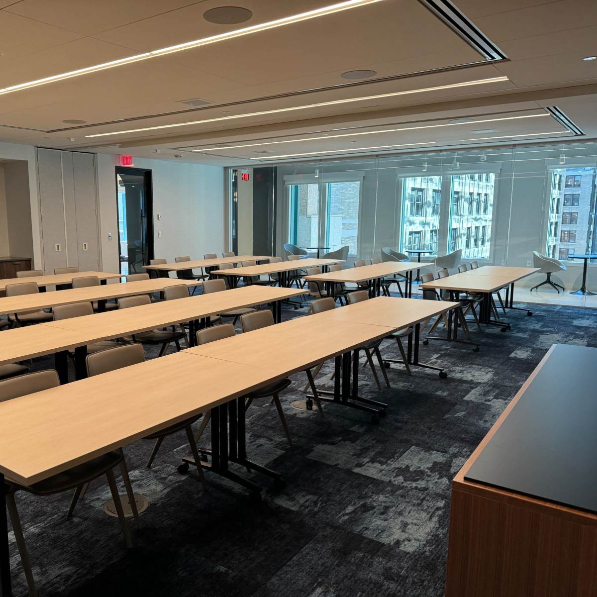 A spacious conference room with several rows of tables and chairs arranged for a meeting.