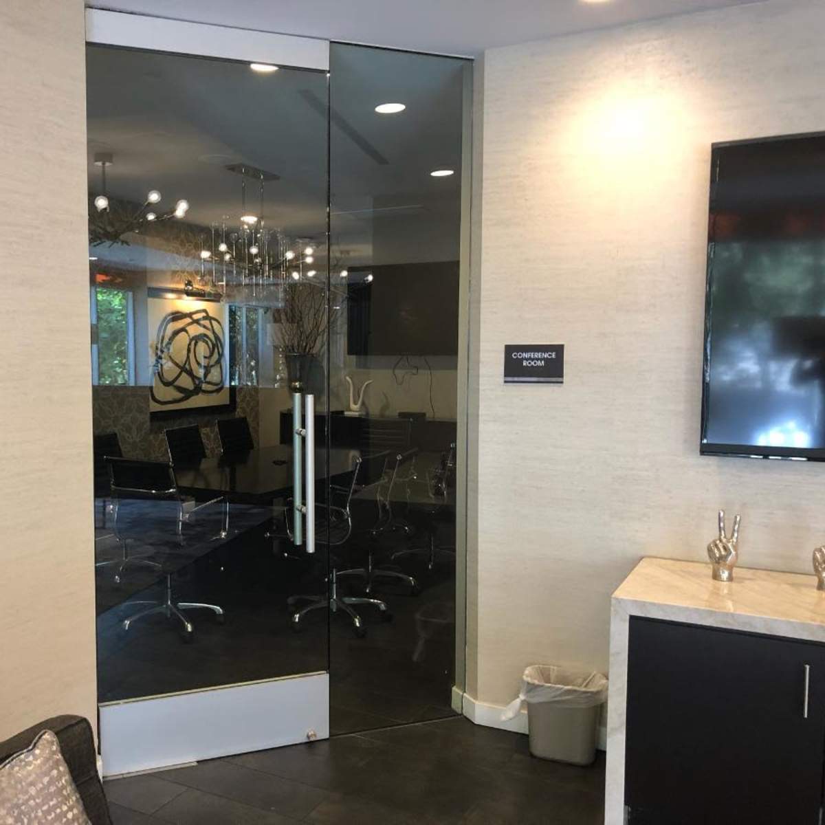 A modern conference room with a glass door and a sign indicating "Conference Room."