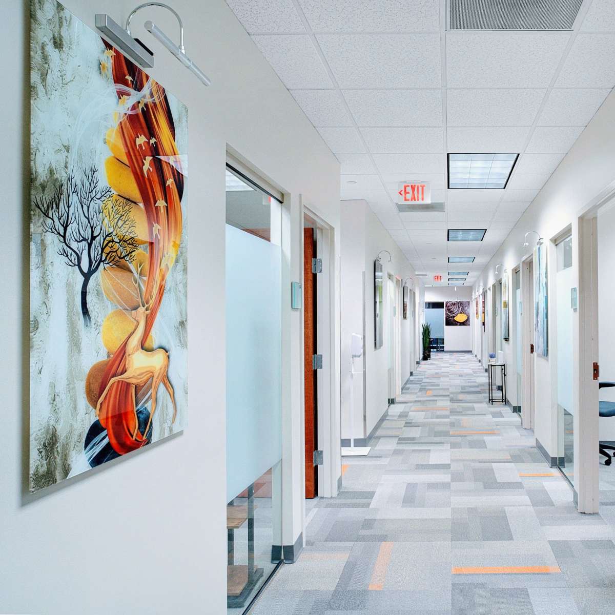 A well-lit corridor features several doors on both sides and an abstract painting on the wall.
