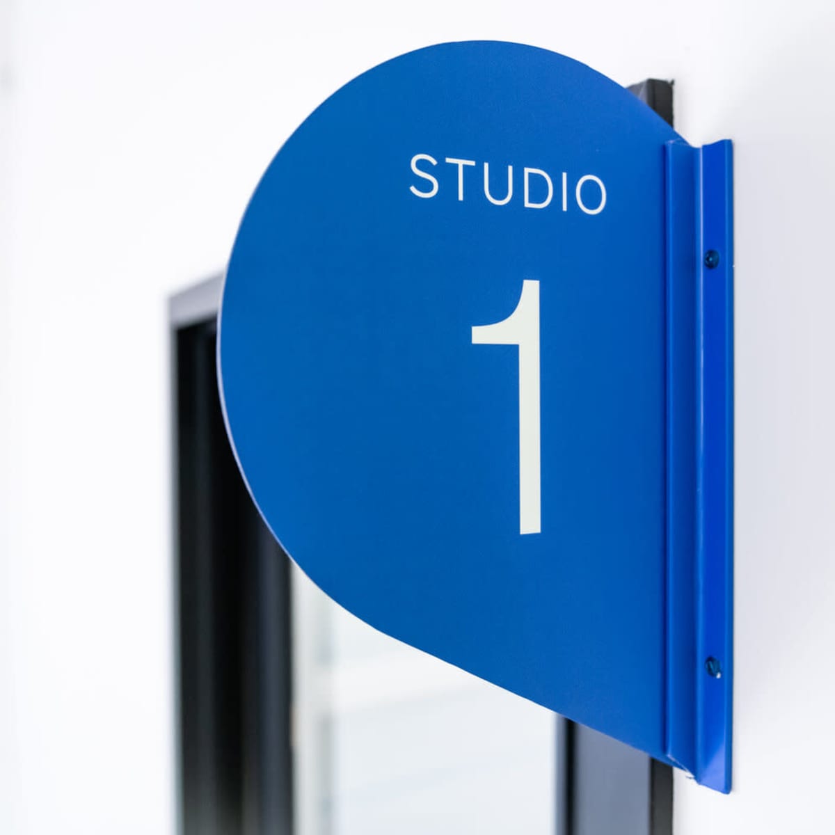 A blue sign on a wall that reads "STUDIO 1."