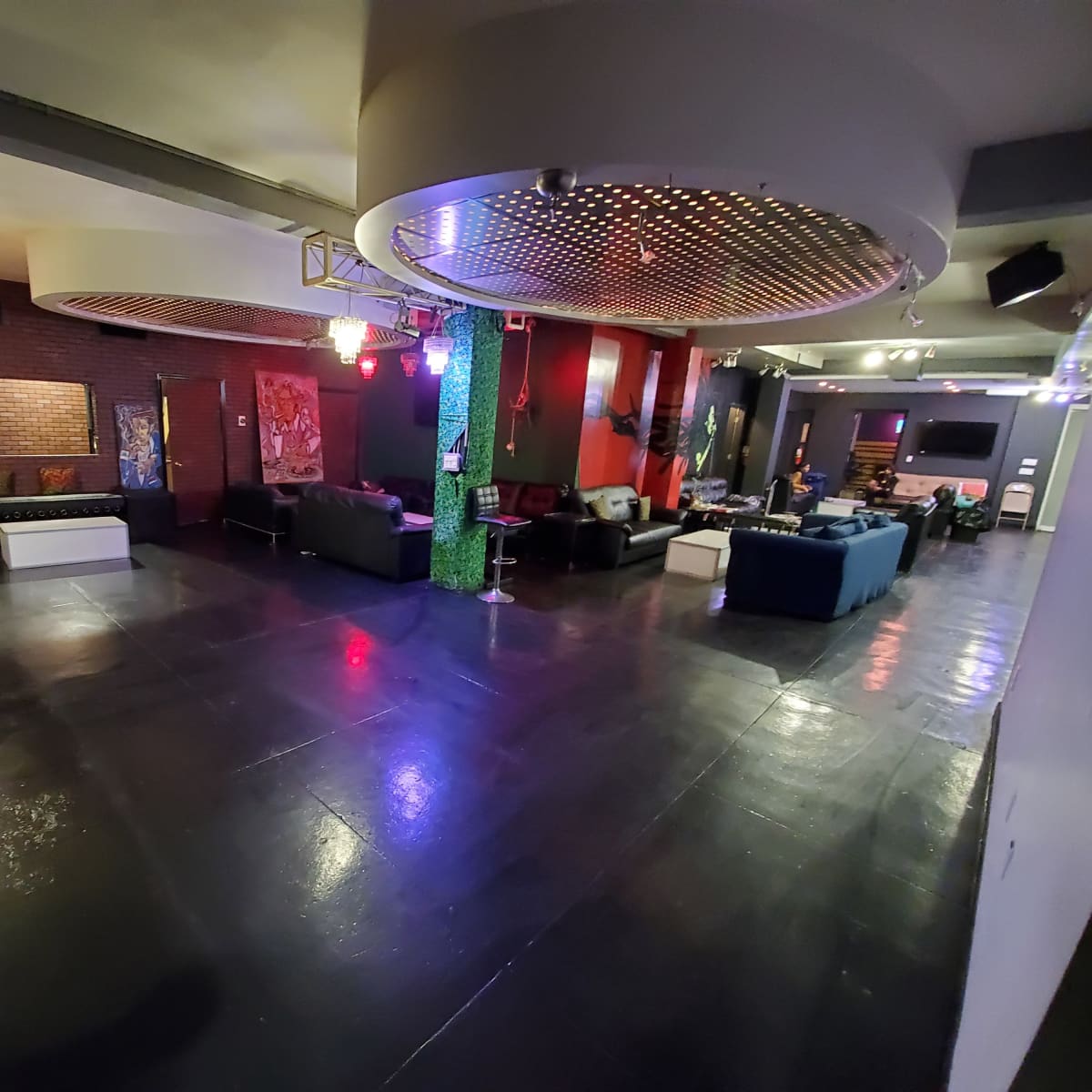 A spacious lounge area with modern furniture, varied seating arrangements, and decorative lighting.