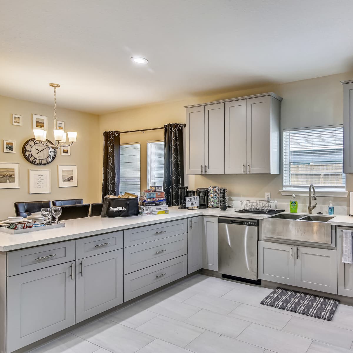 A modern kitchen featuring light gray cabinets, stainless steel appliances, and a countertop with a sink and a window.