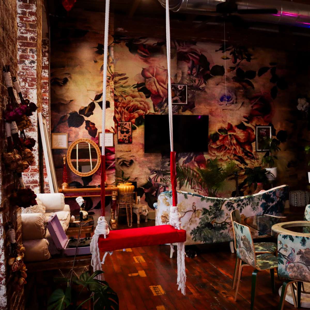 The scene features a cafe with vintage-style swings, a floral wallpaper backdrop, and a green wall adorned with heart-shaped neon lights.