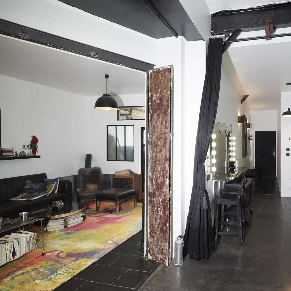A modern, open-concept living space divided between a cozy lounge area and a dining area with a sleek table and chairs.