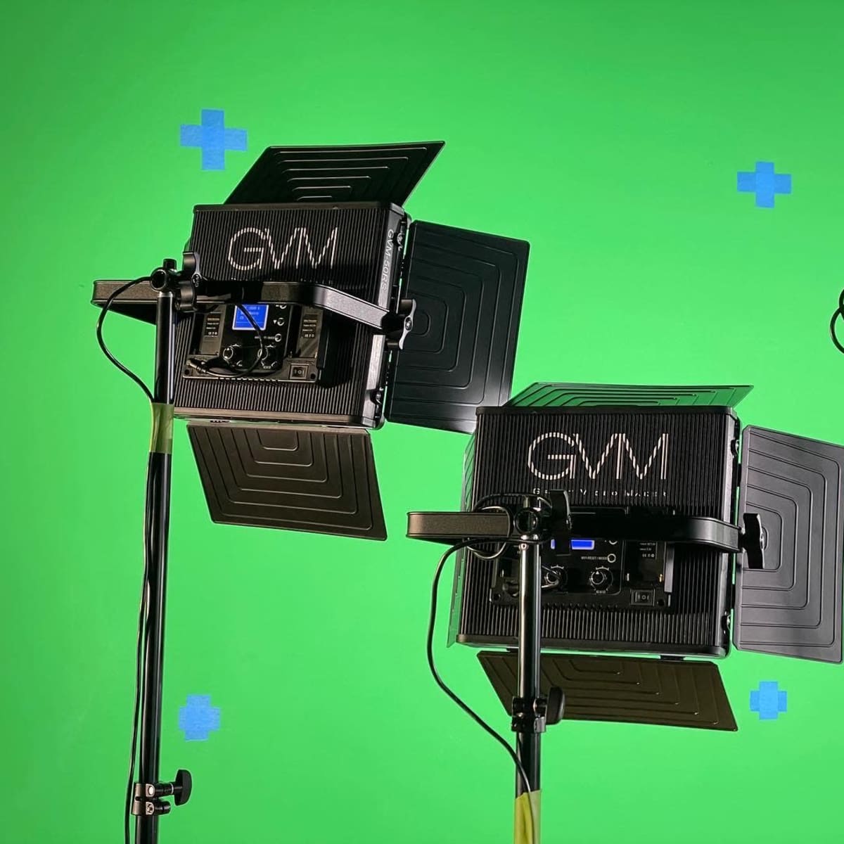 Two studio lights positioned in front of a green screen, with marked locations for potential visual effects.