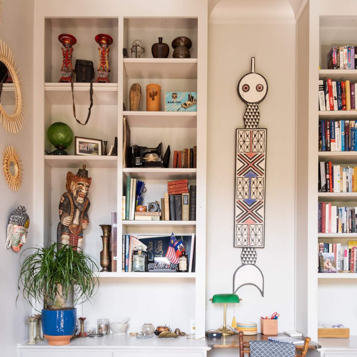 A cozy living room corner featuring a bookshelf filled with decorative items and books, a wooden chair, and a patterned rug.