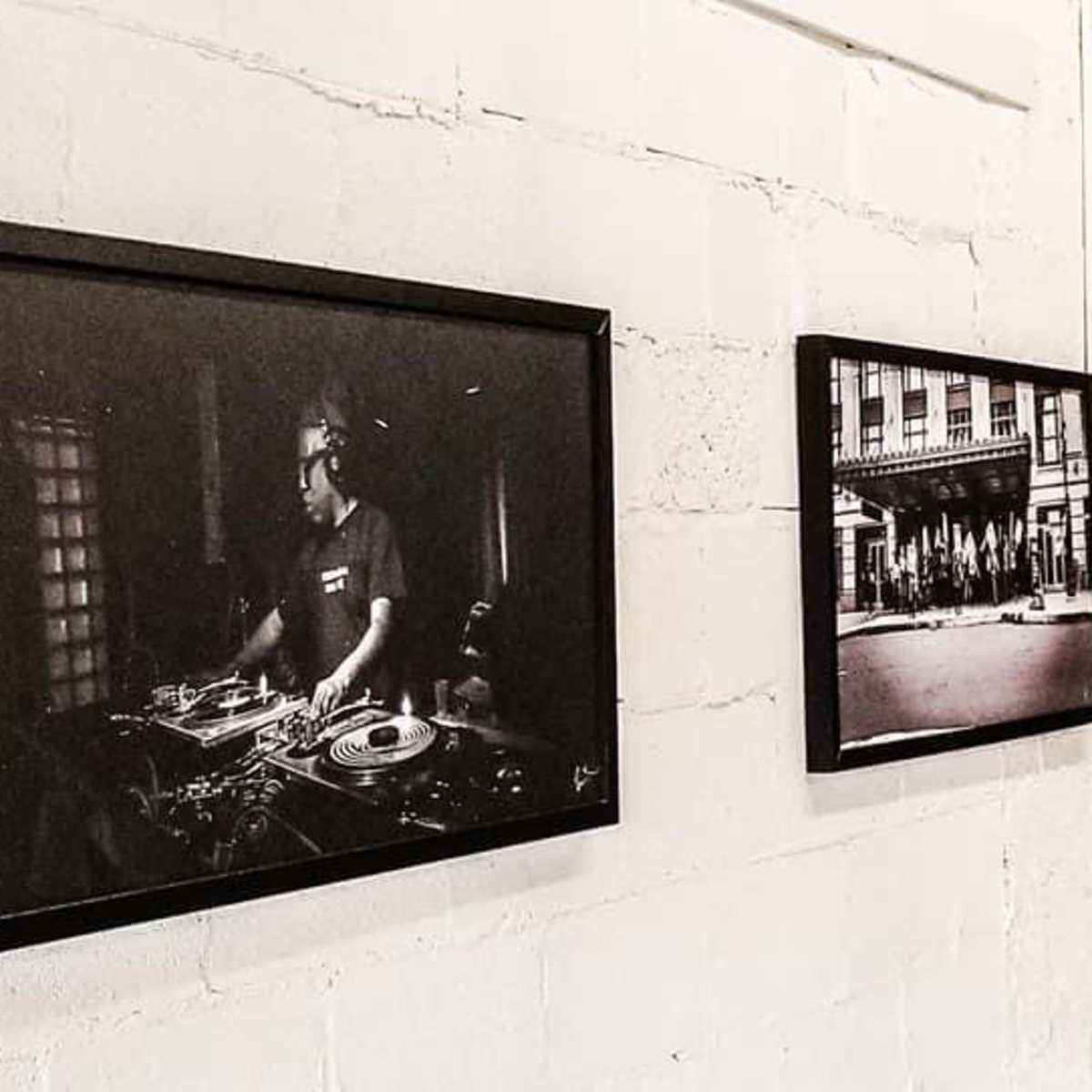 A series of black-and-white photographs framed and displayed on a wall.