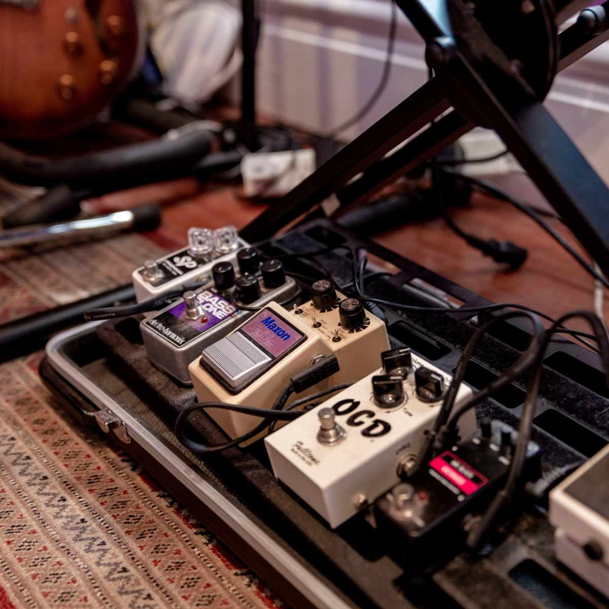 A close-up view of a collection of guitar effects pedals arranged on a pedalboard.
