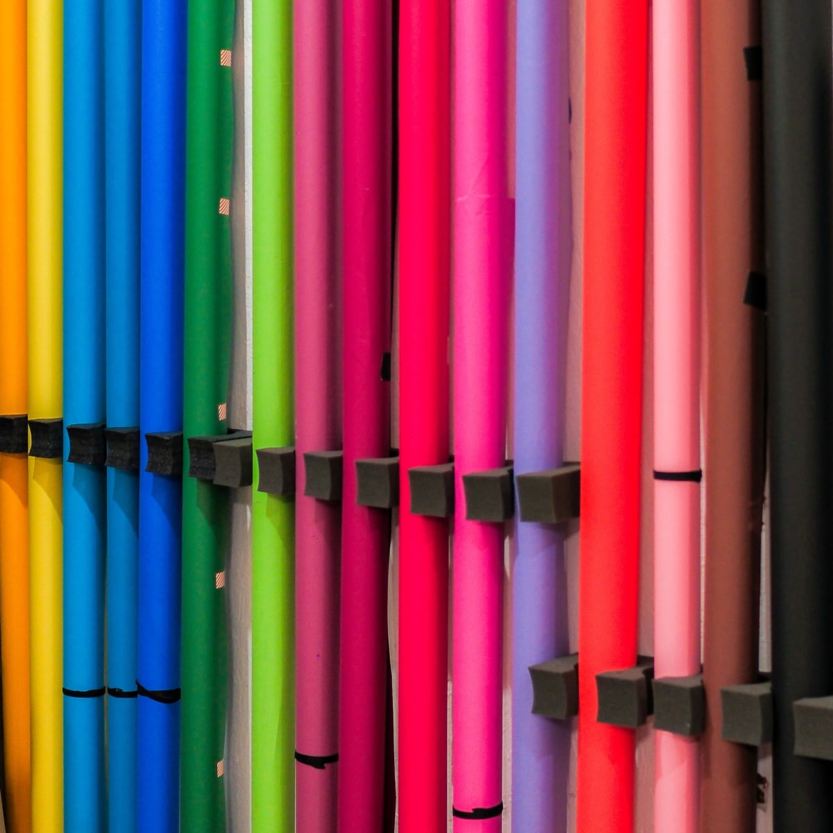 A collection of rolled craft paper in various colors is neatly arranged on display.