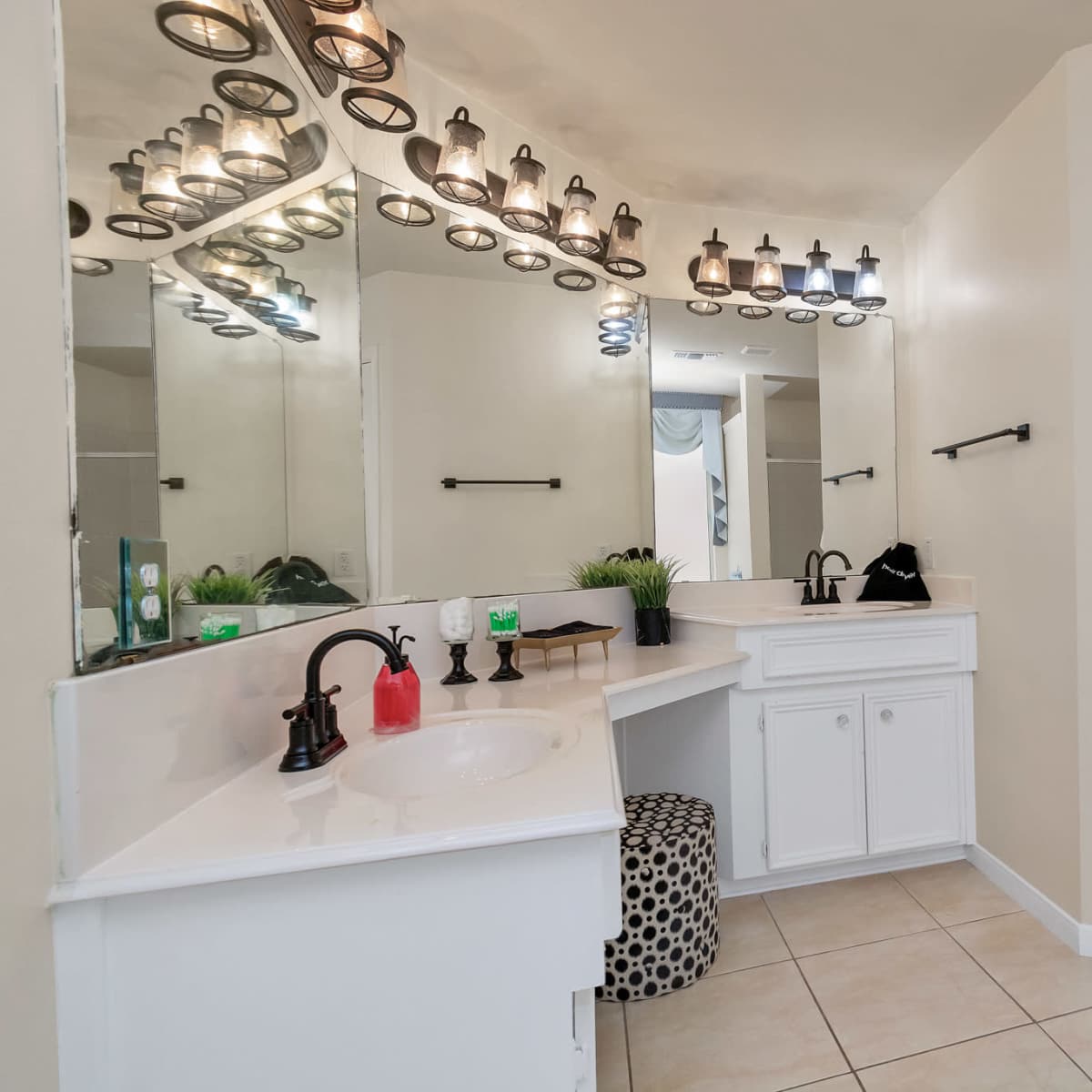 A well-lit bathroom features a spacious countertop, a large mirror, and neatly hung towels.
