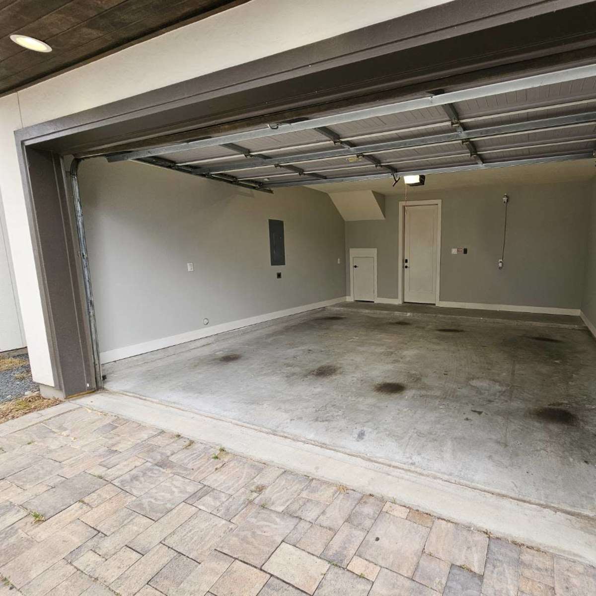 An empty garage with a gray interior and a concrete floor.
