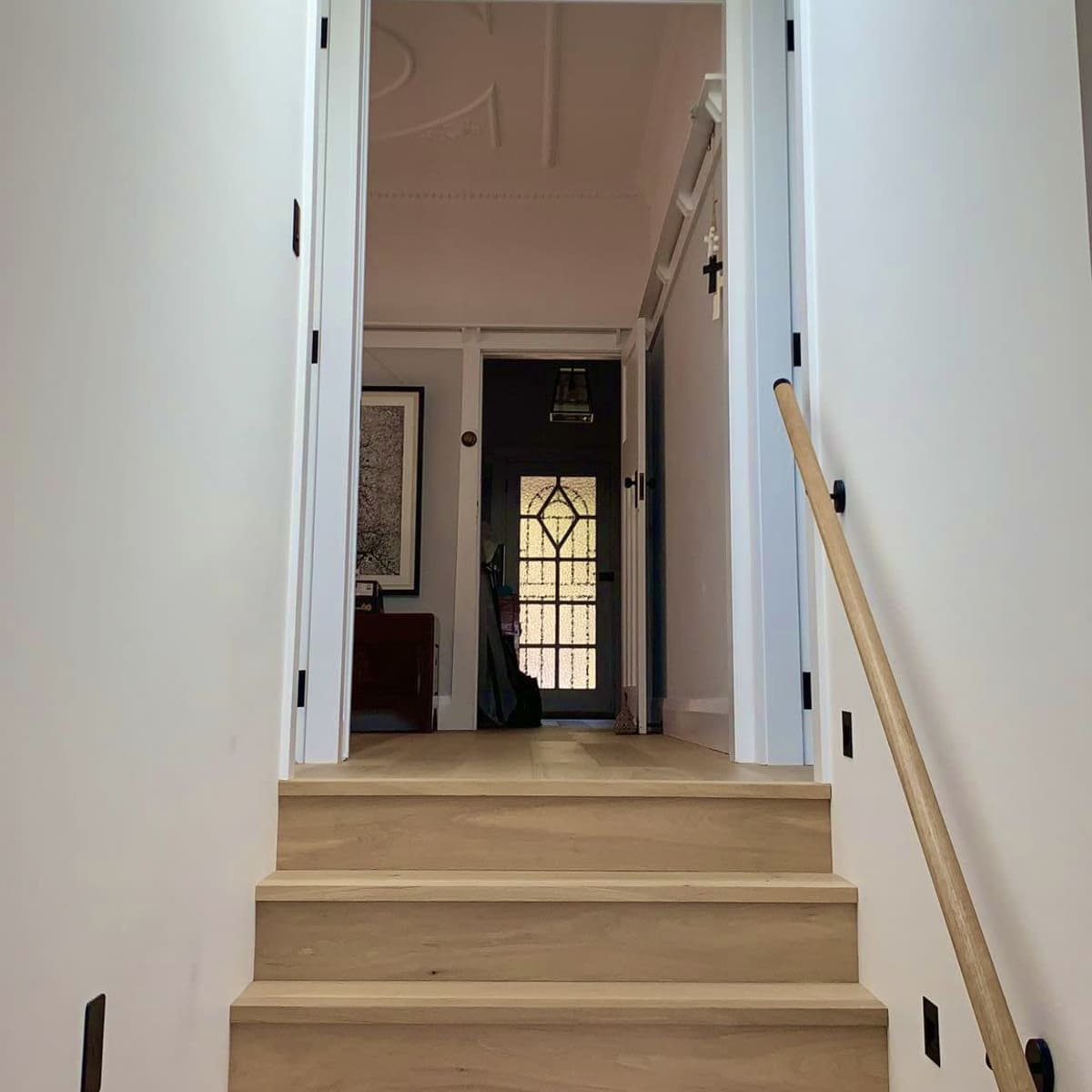 A staircase leads to a hallway with a skylight and doors on either side.