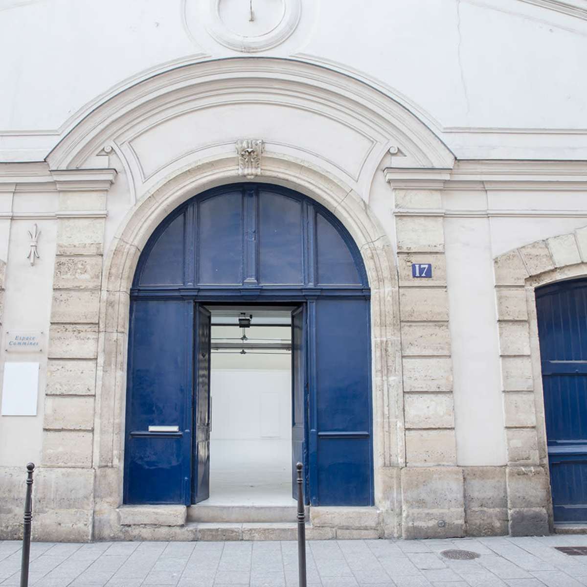 A building entrance with arched blue doors and a stone facade.