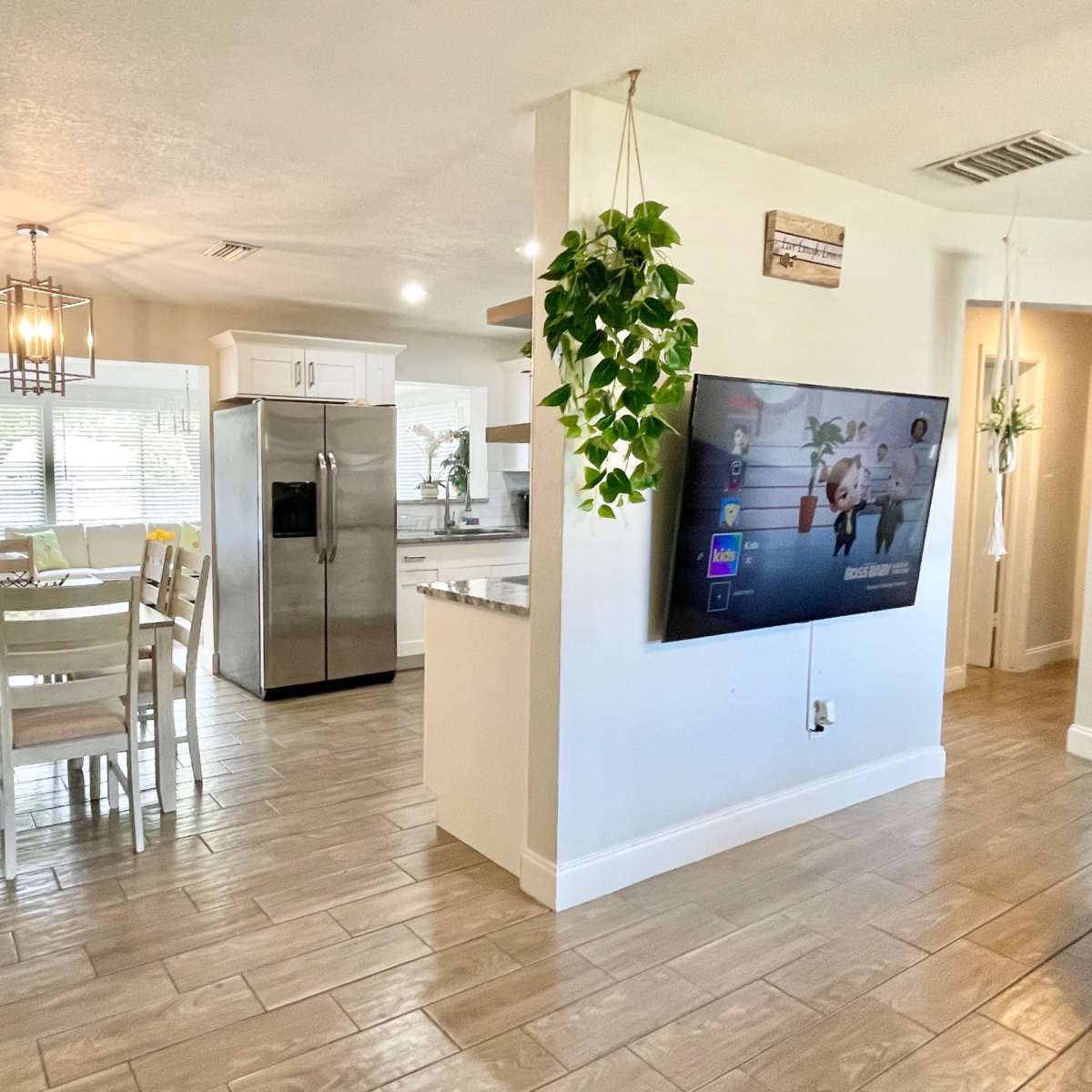 A modern kitchen and dining area with a table set for four and large windows providing natural light.