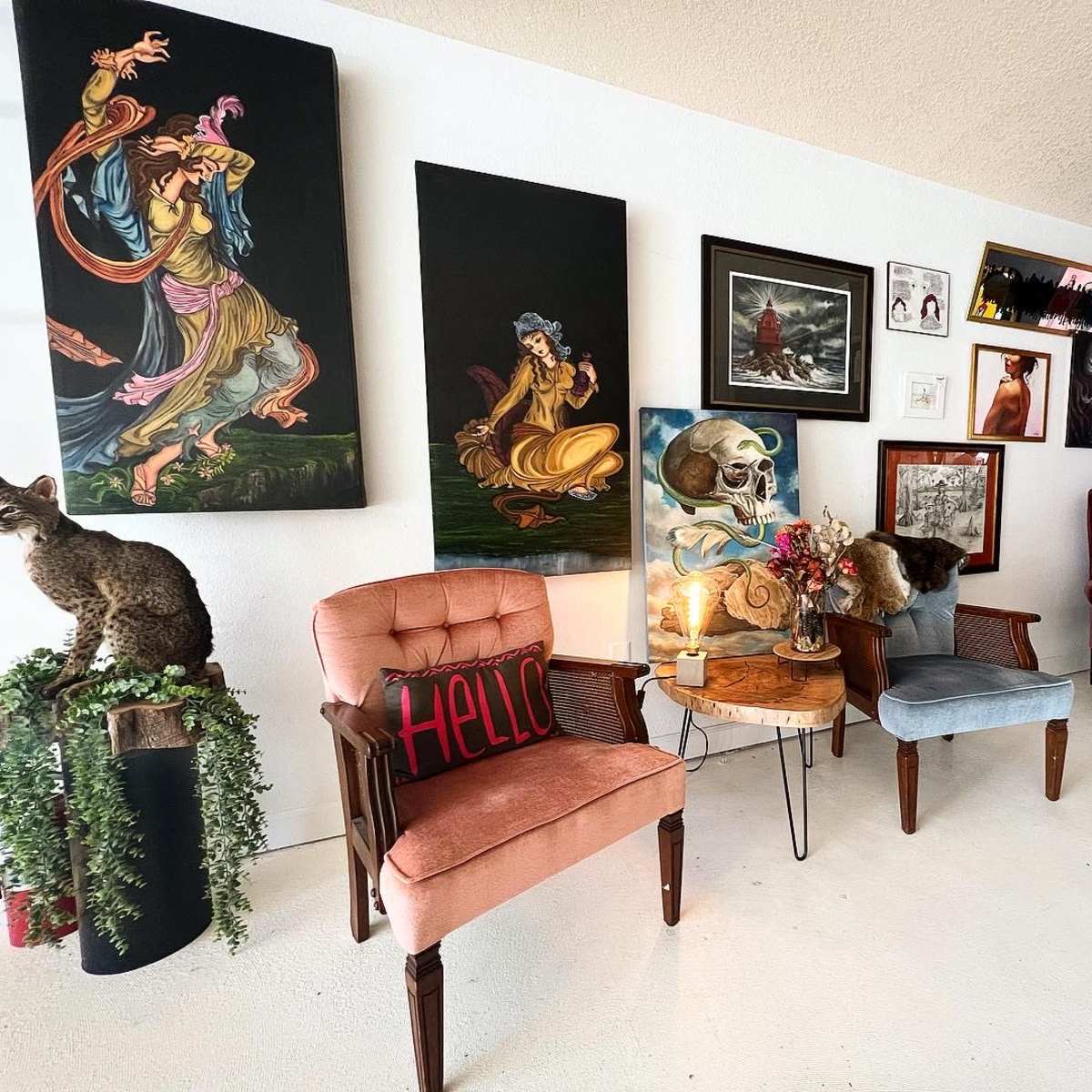 An eclectic seating area with various styled chairs, decorated walls featuring multiple artworks, and a small table with decorative items.