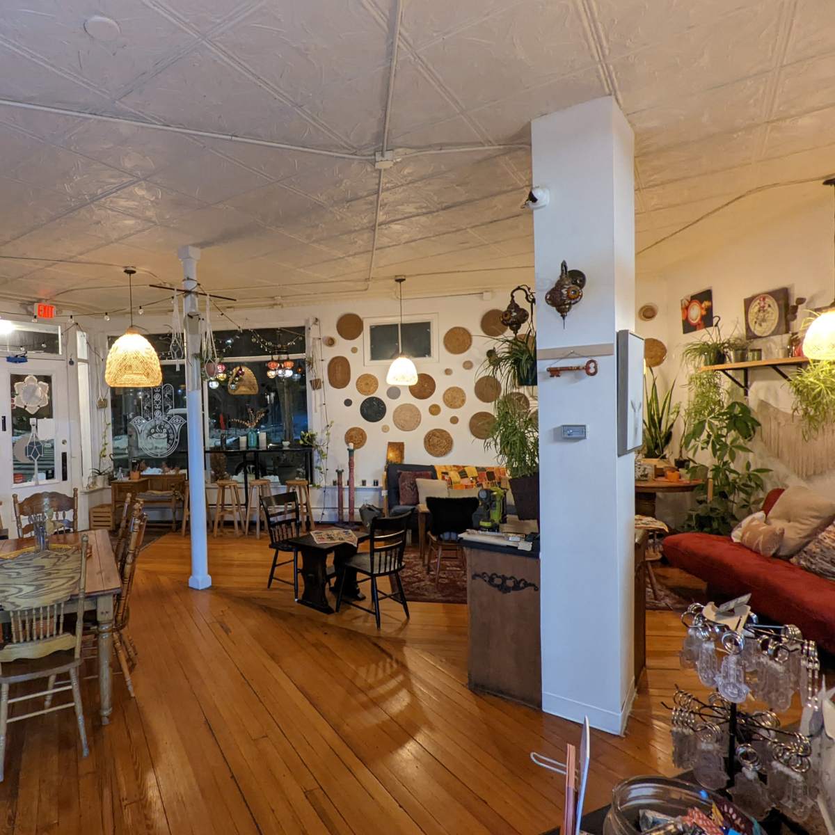 A cozy café interior with wooden floors, a mix of seating arrangements, and decorative wall art.