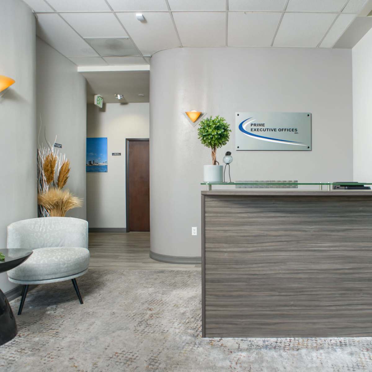 A modern reception area with a wooden front desk, plants, and seating arrangements.