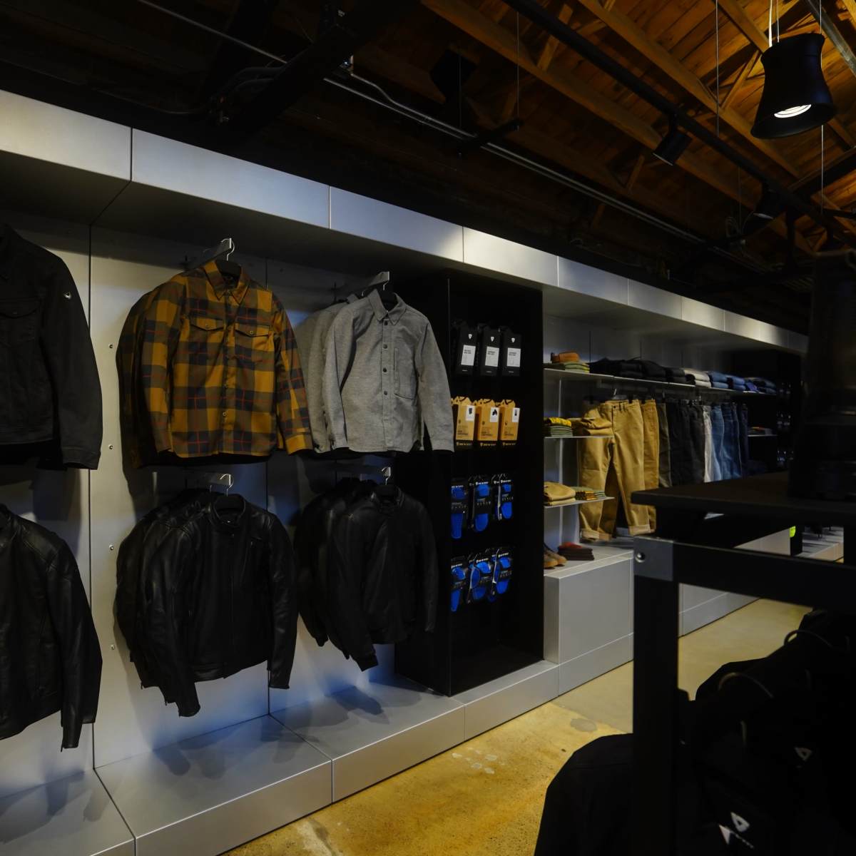 A retail display of various jackets and clothing items arranged on hangers and shelves in a store.