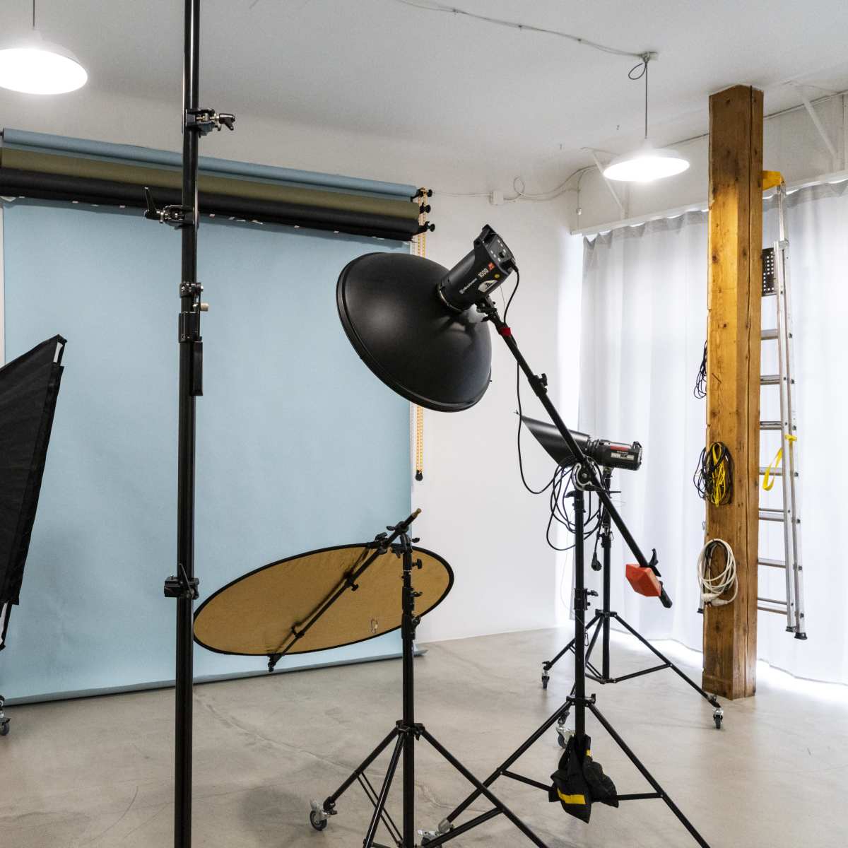 A photography studio equipped with lighting equipment, a backdrop, and various tools for taking pictures.