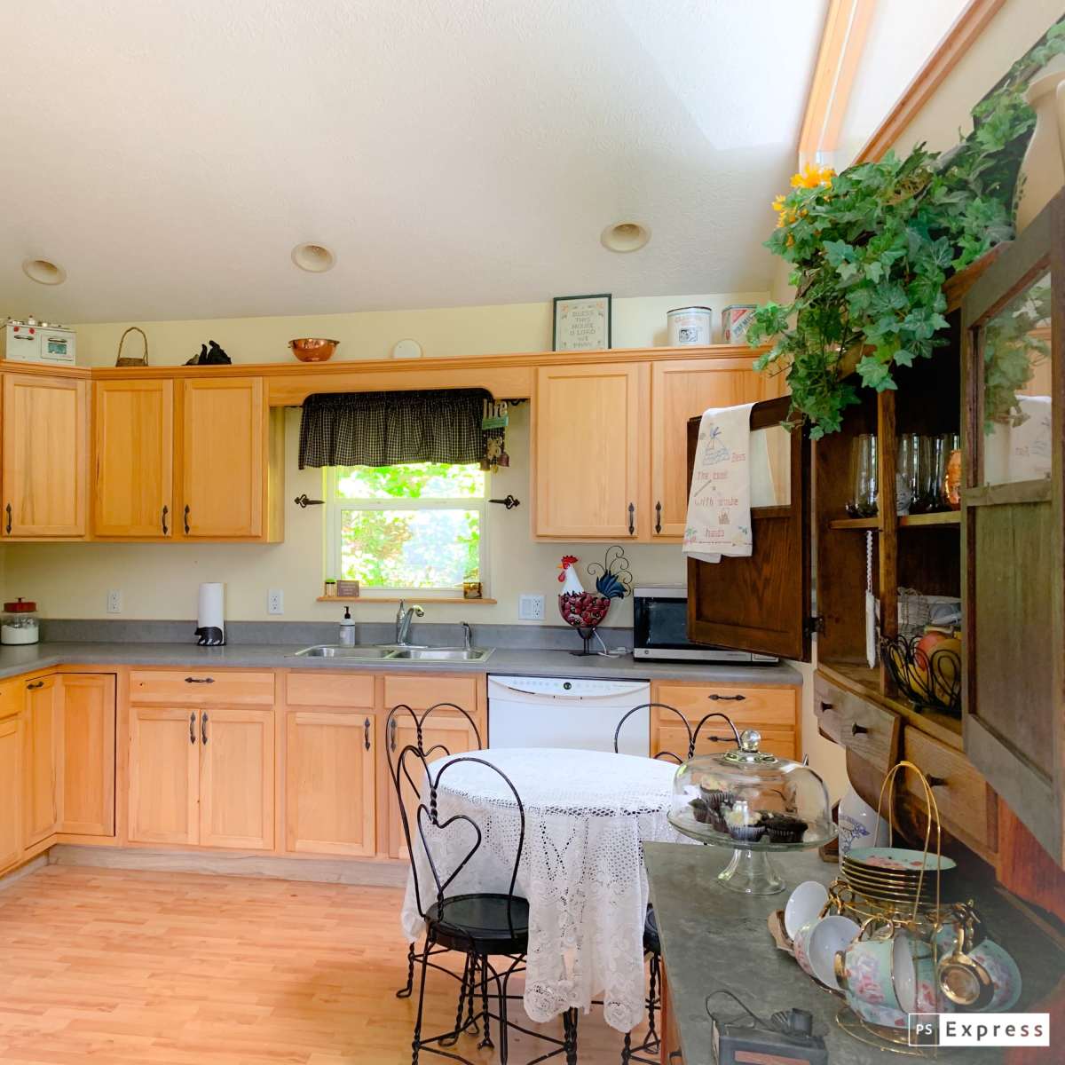 A modern kitchen with wooden cabinets, a countertop, and a small dining table set for two.