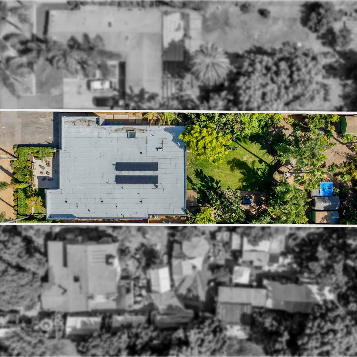 An aerial view of a large building surrounded by a garden and trees, with surrounding residential structures visible.