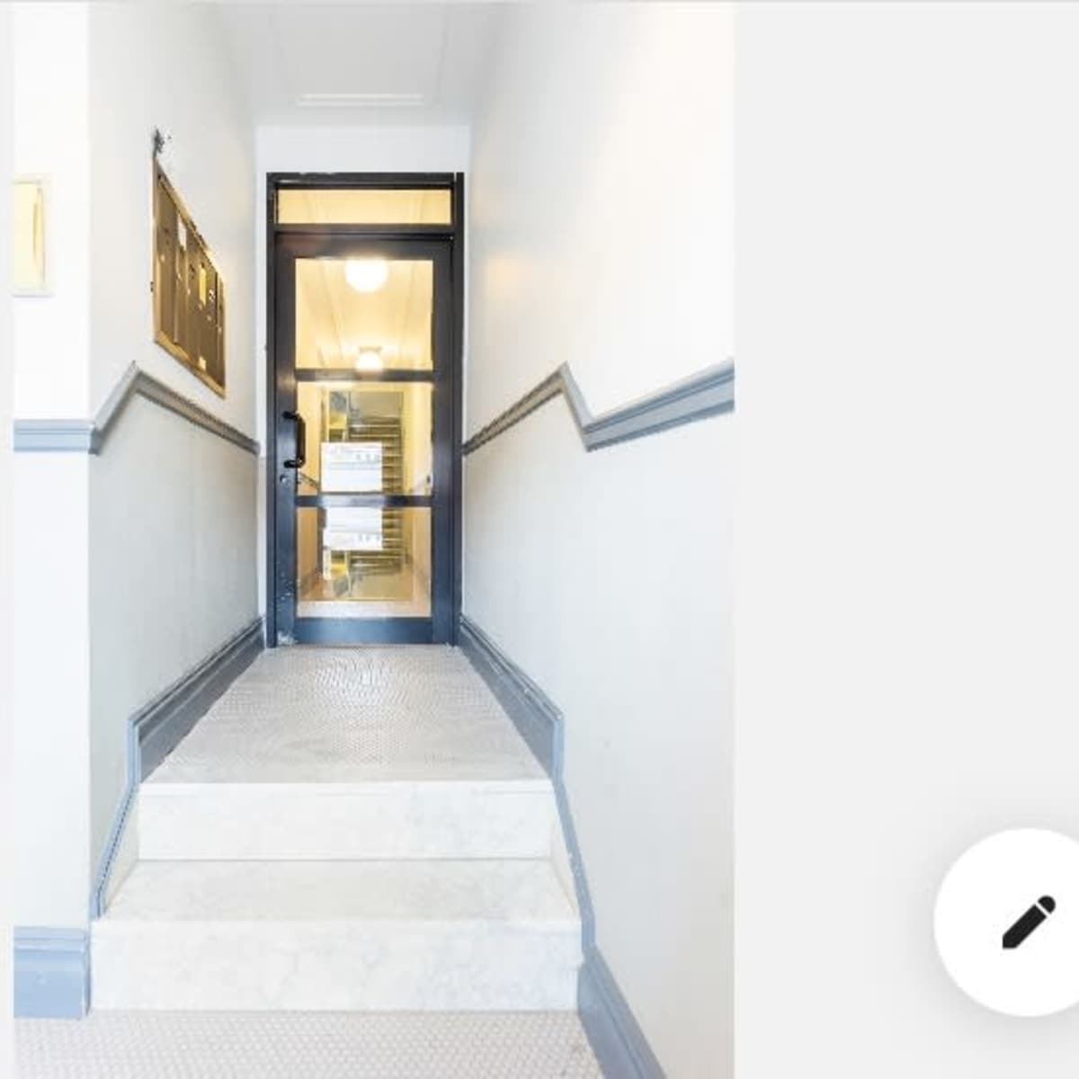 A set of stairs leads up to a glass door located at the top, with a notice posted on it.