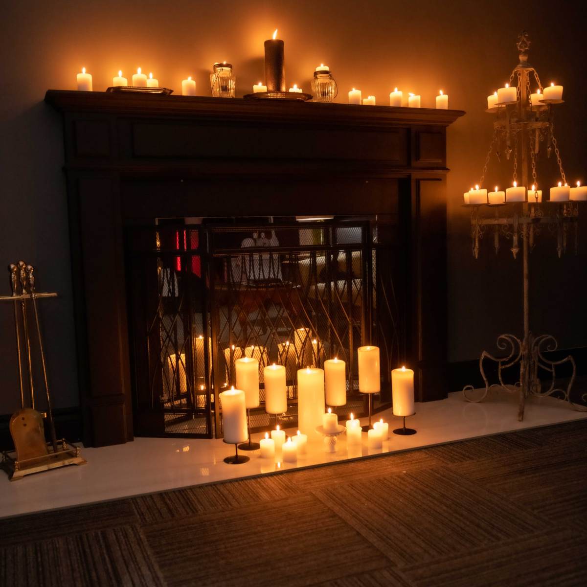 A fireplace adorned with numerous lit candles creates a warm and inviting atmosphere in a dimly lit room.
